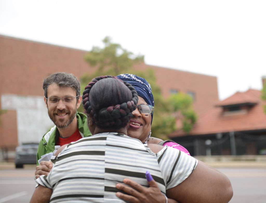 The Rev. Nick Larson looks on as Edith Prince hugs Sheila Ruffin
